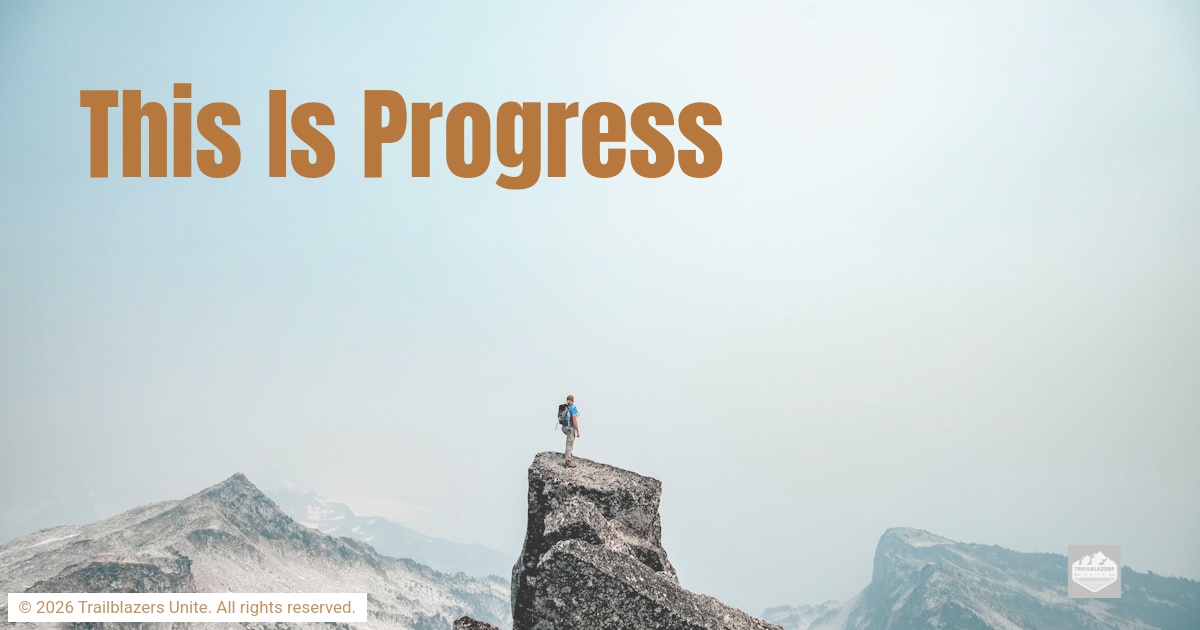 Person standing on a rocky mountain peak overlooking distant ranges, symbolizing perspective, achievement, and steady progress.